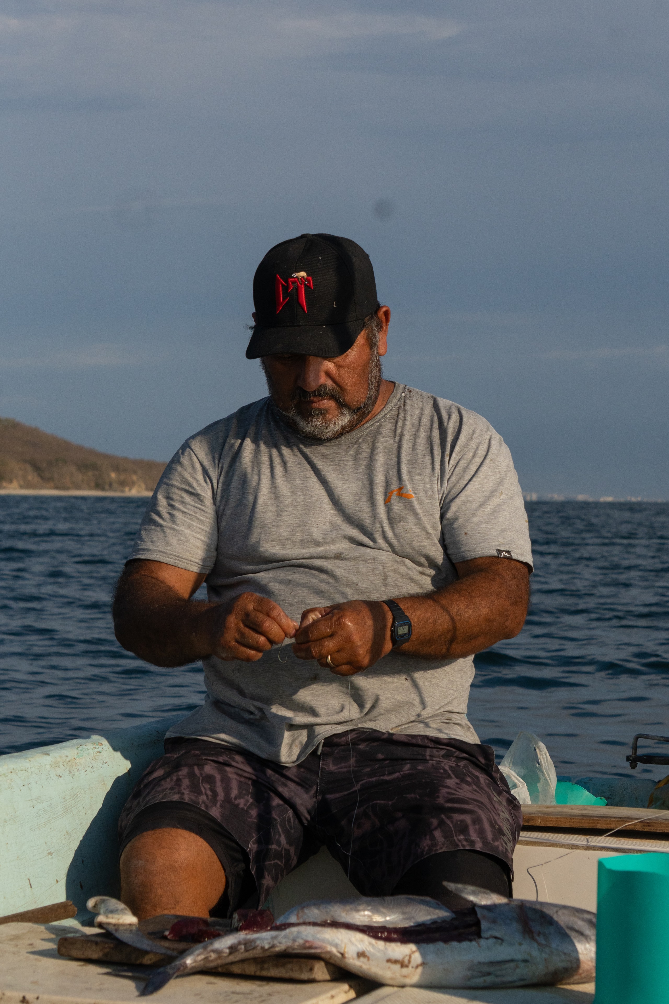 Pescador en barco azul con su captura