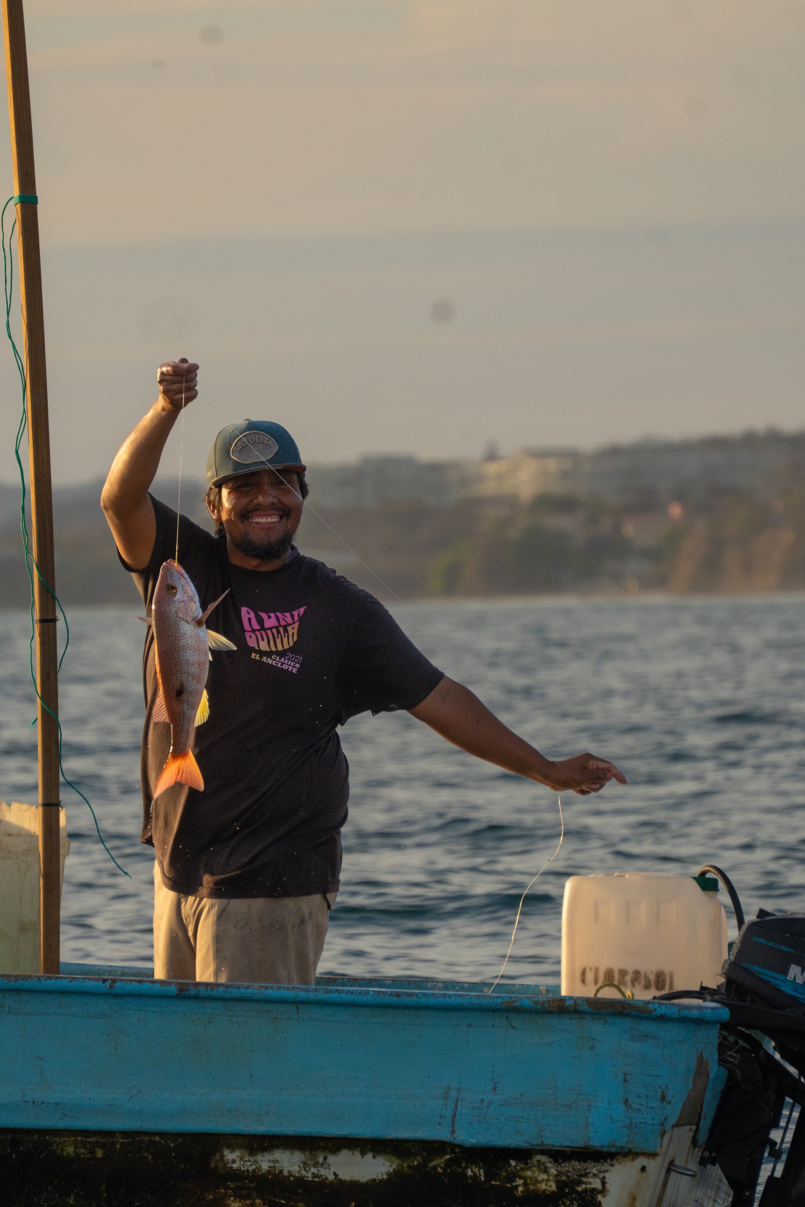 Pescador sosteniendo un pez en el barco